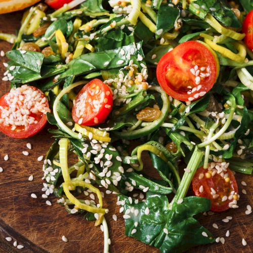 Fresh bouquet of flowers with red, orange, and yellow blooms resting on a wooden table. End.