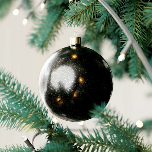 A close-up of a Christmas tree with a shiny black ornament and string lights.